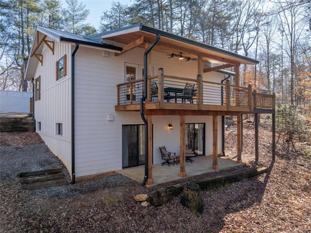 rear view of house with ceiling fan, a balcony, and a patio area