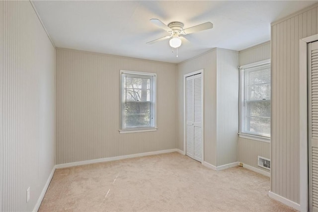 unfurnished bedroom featuring a ceiling fan, carpet flooring, visible vents, and baseboards