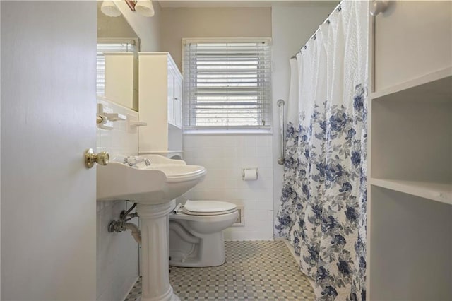 bathroom with a shower with curtain, tile walls, and toilet