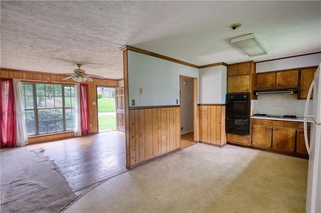 1342 Peggy Ln NW, Conyers, GA 30012 - kitchen with ventilation hood, wood walls, stainless steel gas stovetop, ornamental molding, and brown cabinets