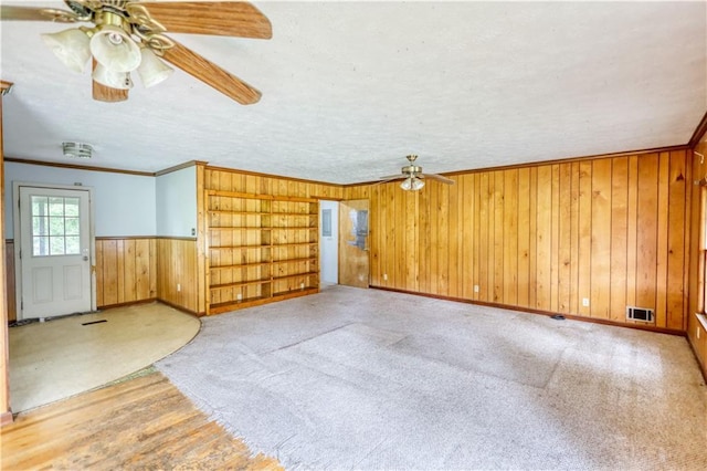 1342 Peggy Ln NW, Conyers, GA 30012 - empty room featuring a ceiling fan, wood walls, ornamental molding, carpet floors, and wainscoting