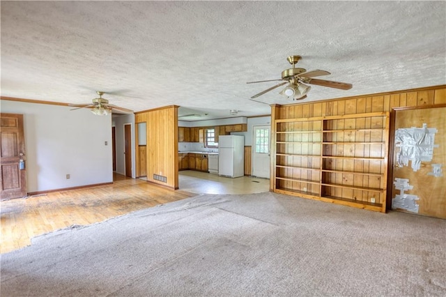 1342 Peggy Ln NW, Conyers, GA 30012 - unfurnished living room with ceiling fan, crown molding, a textured ceiling, light carpet, and wooden walls