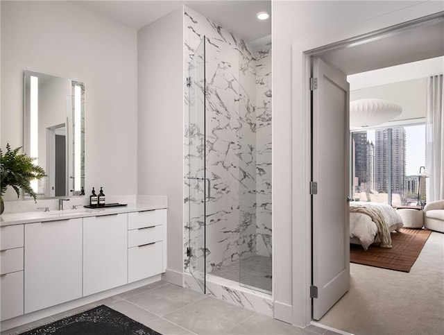 bathroom featuring a shower with shower door, vanity, and tile patterned flooring