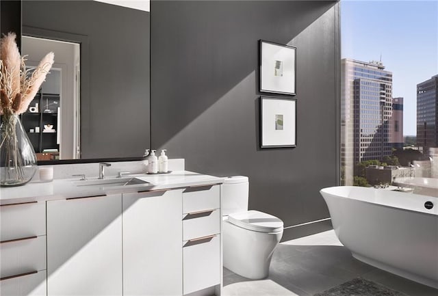 bathroom featuring toilet, a tub to relax in, and vanity