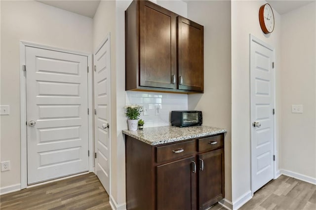 115 Copeland Bnd, Jasper, GA 30143 - kitchen with light wood-style flooring, decorative backsplash, dark brown cabinets, and baseboards