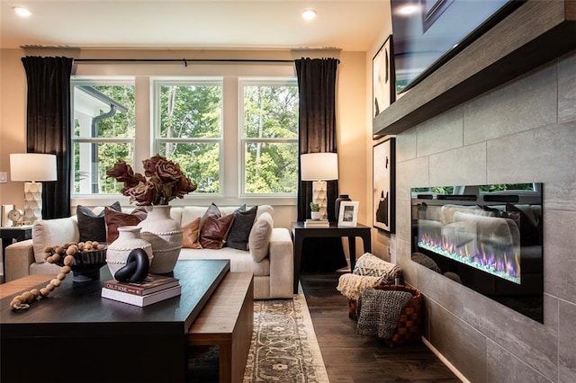 living room featuring dark hardwood / wood-style flooring, a fireplace, and tile walls