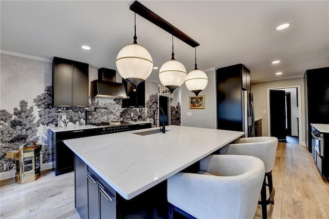 kitchen featuring pendant lighting, sink, and an island with sink