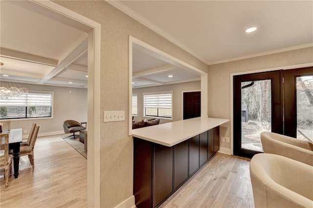 interior space featuring coffered ceiling, beamed ceiling, a healthy amount of sunlight, and light wood-type flooring