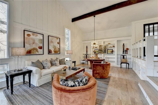 living room with beamed ceiling, a healthy amount of sunlight, high vaulted ceiling, and light wood-type flooring