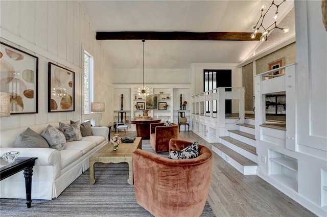 living room with lofted ceiling with beams, a chandelier, hardwood / wood-style floors, and built in shelves