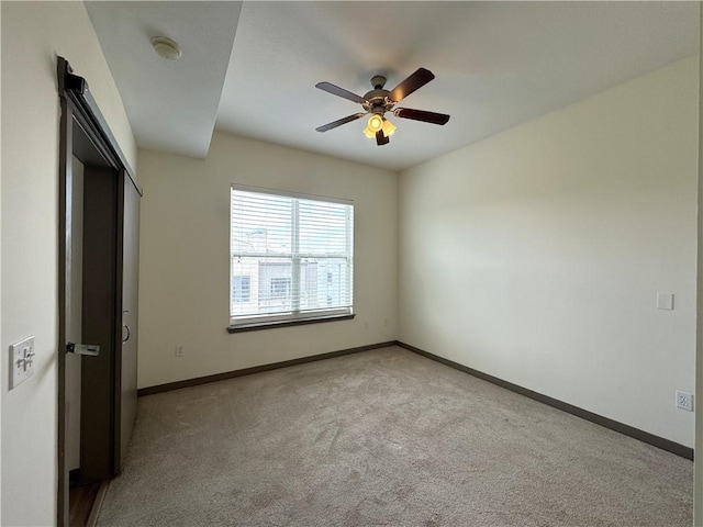 unfurnished bedroom featuring light colored carpet, baseboards, and ceiling fan