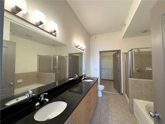 bathroom featuring tile patterned floors, a stall shower, a bath, double vanity, and a spacious closet