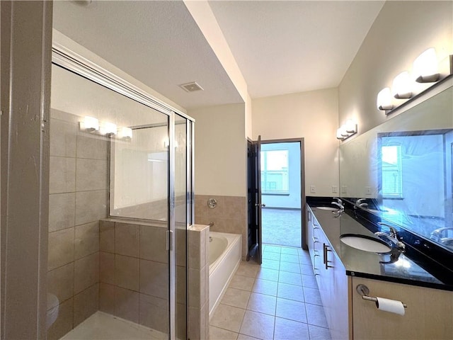 full bath with tile patterned floors, a garden tub, a stall shower, and double vanity