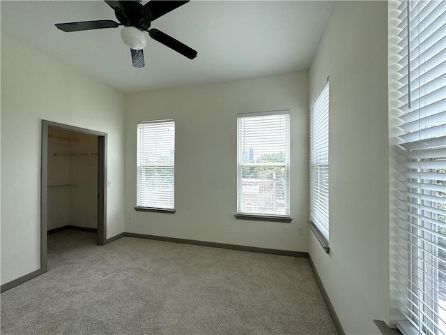 unfurnished bedroom featuring carpet floors, multiple windows, and baseboards