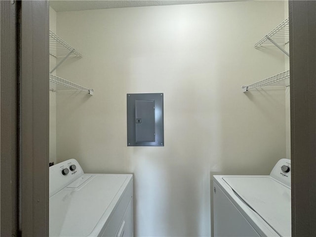 laundry area with electric panel and washer and clothes dryer