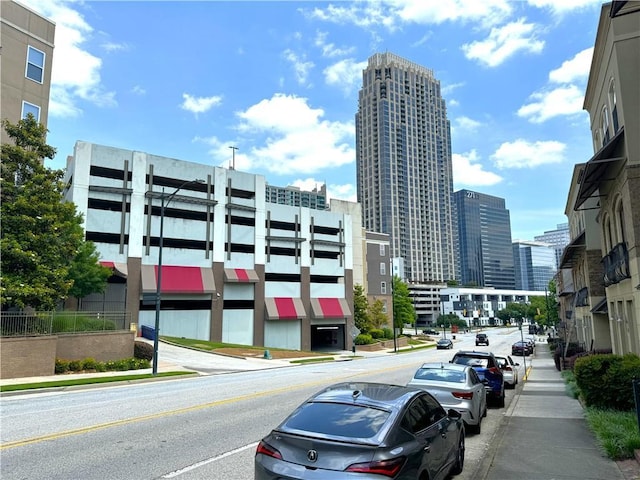 view of asphalt road with sidewalks, a view of city, and curbs