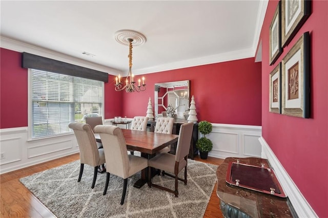 852 Van Briggle Path, Sugar Hill, GA 30518 - dining room featuring a chandelier, wainscoting, crown molding, wood finished floors, and a decorative wall