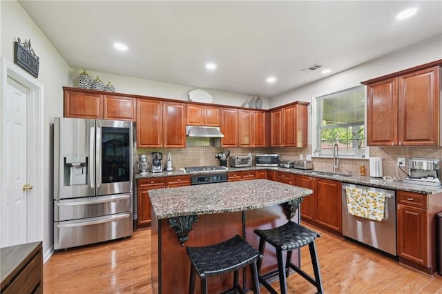 852 Van Briggle Path, Sugar Hill, GA 30518 - kitchen with stainless steel appliances, under cabinet range hood, light stone counters, light wood-style floors, and recessed lighting