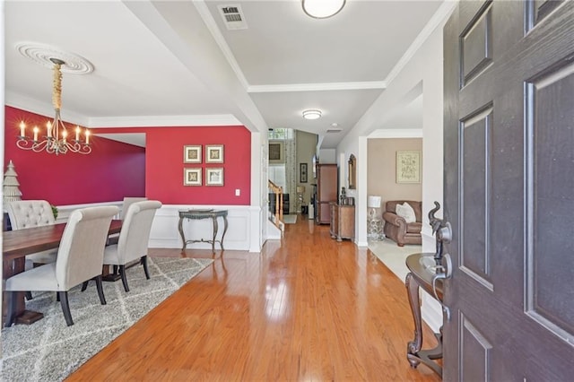 852 Van Briggle Path, Sugar Hill, GA 30518 - entryway featuring wood finished floors, a chandelier, ornamental molding, and a wainscoted wall