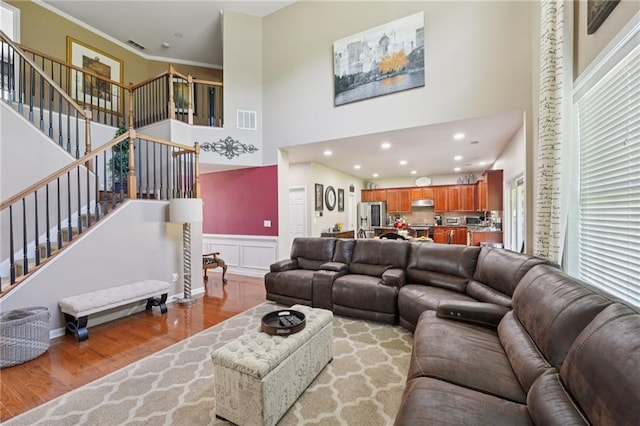 852 Van Briggle Path, Sugar Hill, GA 30518 - living room with wood finished floors, a high ceiling, stairs, a wainscoted wall, and ornamental molding