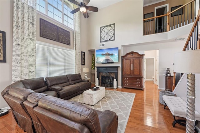 852 Van Briggle Path, Sugar Hill, GA 30518 - living room featuring a high ceiling, a ceiling fan, light wood finished floors, stairway, and a fireplace