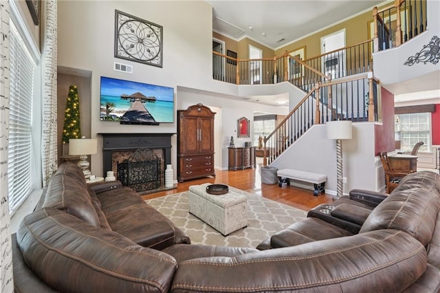 852 Van Briggle Path, Sugar Hill, GA 30518 - living room featuring a towering ceiling, ornamental molding, stairs, a fireplace, and wood finished floors
