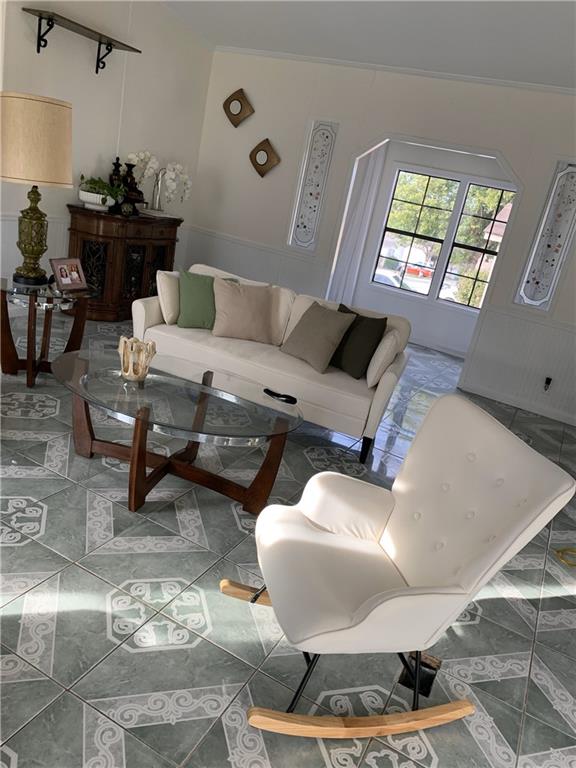 tiled living room featuring crown molding