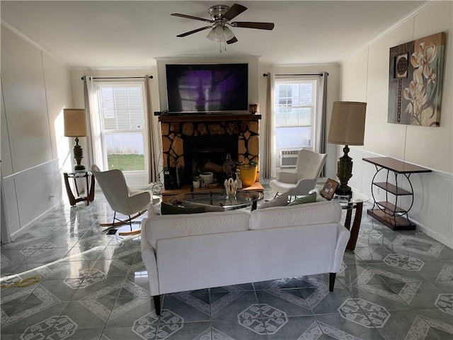 living room featuring a fireplace, cooling unit, ceiling fan, and ornamental molding