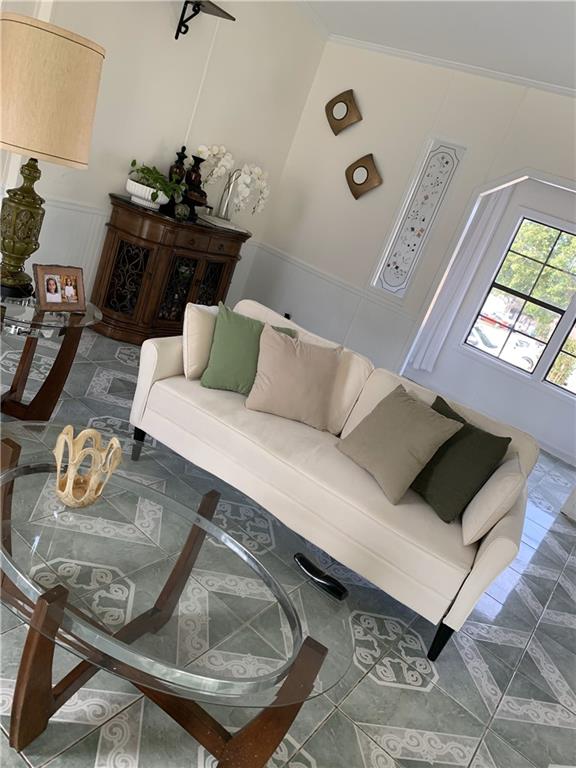 living room featuring crown molding and a high ceiling