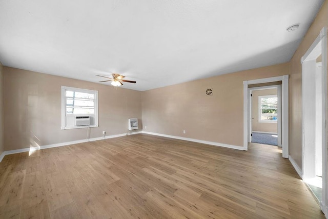 empty room featuring light wood-type flooring, ceiling fan, cooling unit, and heating unit