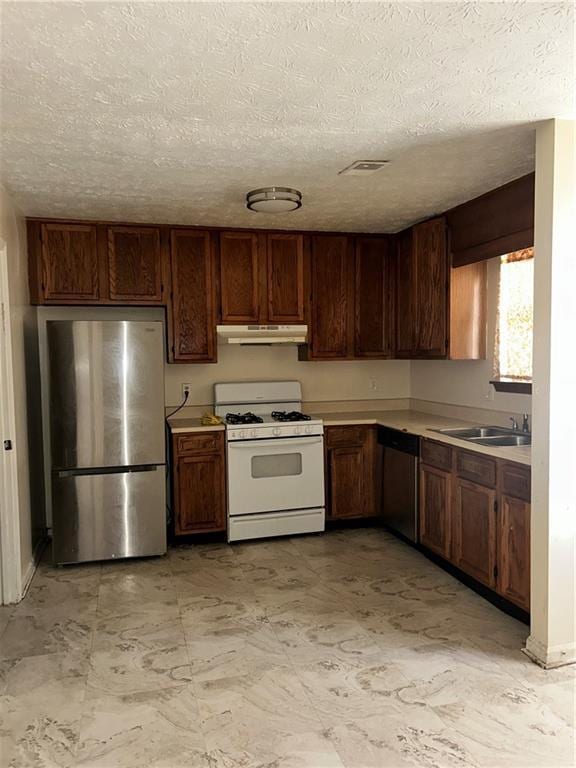 kitchen with visible vents, appliances with stainless steel finishes, light countertops, under cabinet range hood, and a sink