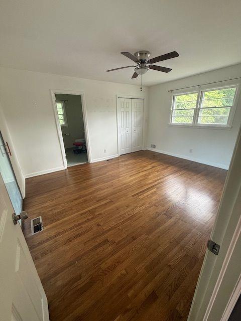 2190 Olive Springs Rd SE, Marietta, GA 30060 - unfurnished bedroom with dark wood finished floors, baseboards, ceiling fan, and a closet