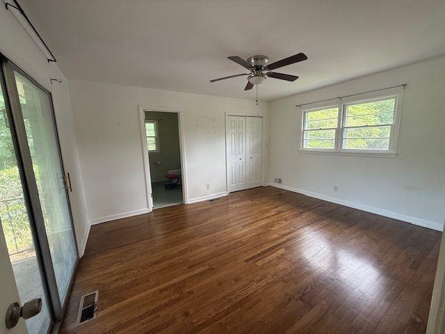 2190 Olive Springs Rd SE, Marietta, GA 30060 - unfurnished bedroom featuring wood finished floors, baseboards, connected bathroom, and a ceiling fan