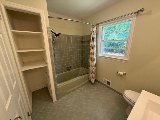 2190 Olive Springs Rd SE, Marietta, GA 30060 - full bathroom with toilet, shower / bathtub combination with curtain, and baseboards