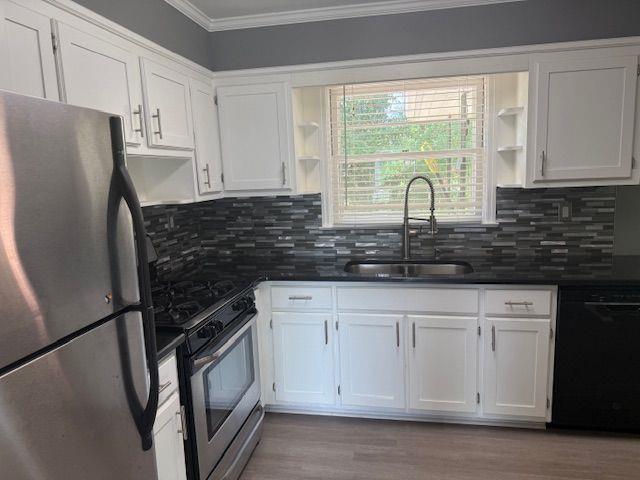 2190 Olive Springs Rd SE, Marietta, GA 30060 - kitchen with stainless steel appliances, open shelves, a sink, crown molding, and white cabinets