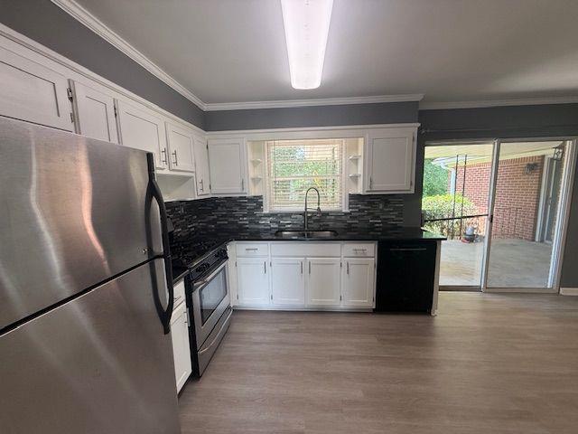 2190 Olive Springs Rd SE, Marietta, GA 30060 - kitchen featuring appliances with stainless steel finishes, a sink, dark countertops, ornamental molding, and wood finished floors