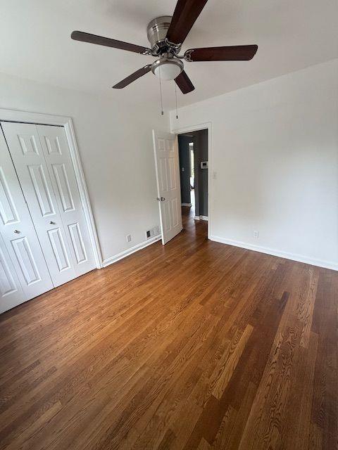 2190 Olive Springs Rd SE, Marietta, GA 30060 - unfurnished bedroom with wood finished floors, baseboards, a ceiling fan, and a closet