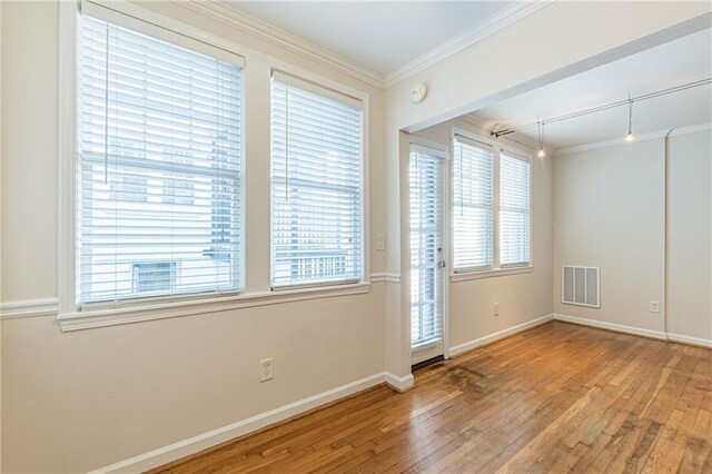 spare room featuring hardwood / wood-style floors and ornamental molding