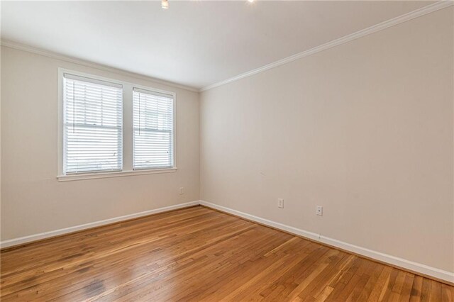 unfurnished room featuring wood-type flooring and ornamental molding