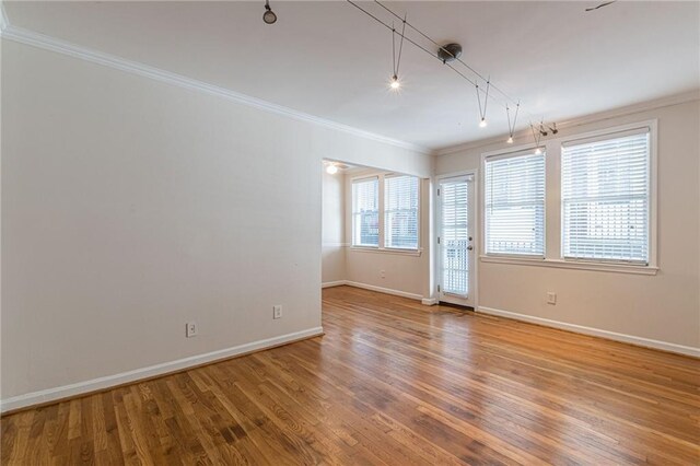 empty room with wood-type flooring and ornamental molding