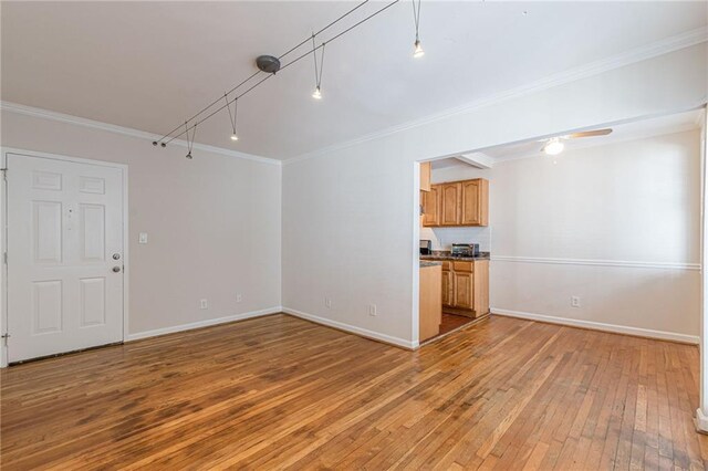 unfurnished living room with hardwood / wood-style flooring, ceiling fan, and crown molding