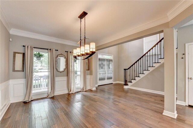 4770 Spring Park Cir, Suwanee, GA 30024 - entrance foyer with crown molding, stairway, a chandelier, wood finished floors, and a wainscoted wall