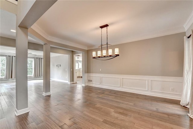 4770 Spring Park Cir, Suwanee, GA 30024 - unfurnished dining area featuring crown molding, a chandelier, a wainscoted wall, and wood finished floors