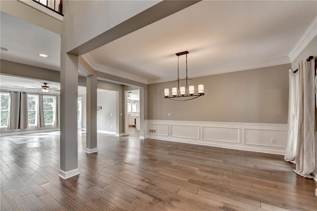 4770 Spring Park Cir, Suwanee, GA 30024 - unfurnished dining area featuring ornamental molding, ceiling fan, wood finished floors, decorative columns, and a wainscoted wall