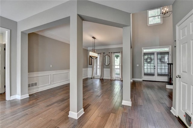 4770 Spring Park Cir, Suwanee, GA 30024 - entrance foyer with a chandelier, dark wood-style flooring, crown molding, a wainscoted wall, and a decorative wall