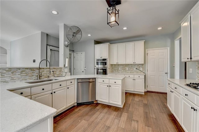 4770 Spring Park Cir, Suwanee, GA 30024 - kitchen with stainless steel appliances, tasteful backsplash, wood finished floors, white cabinets, and recessed lighting