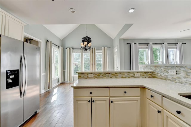 4770 Spring Park Cir, Suwanee, GA 30024 - kitchen with stainless steel refrigerator with ice dispenser, a chandelier, vaulted ceiling, tasteful backsplash, and light wood-type flooring