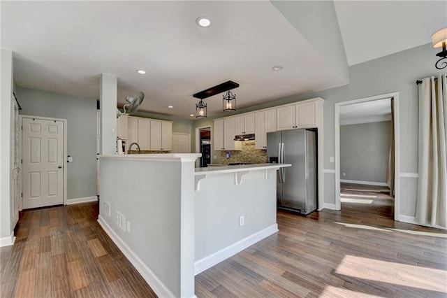 4770 Spring Park Cir, Suwanee, GA 30024 - kitchen with stainless steel fridge with ice dispenser, a peninsula, recessed lighting, under cabinet range hood, and white cabinetry