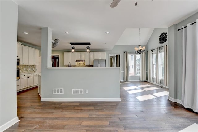4770 Spring Park Cir, Suwanee, GA 30024 - kitchen with freestanding refrigerator, tasteful backsplash, wood finished floors, a chandelier, and white cabinetry