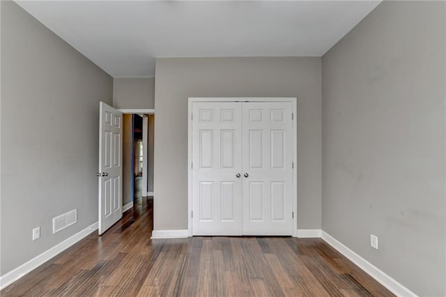 4770 Spring Park Cir, Suwanee, GA 30024 - unfurnished bedroom featuring dark wood-type flooring and a closet